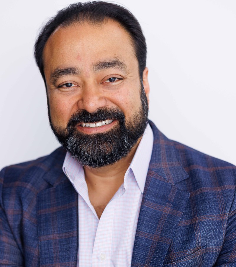 Gautam Kannan, headshot in plaid blazer, smiling