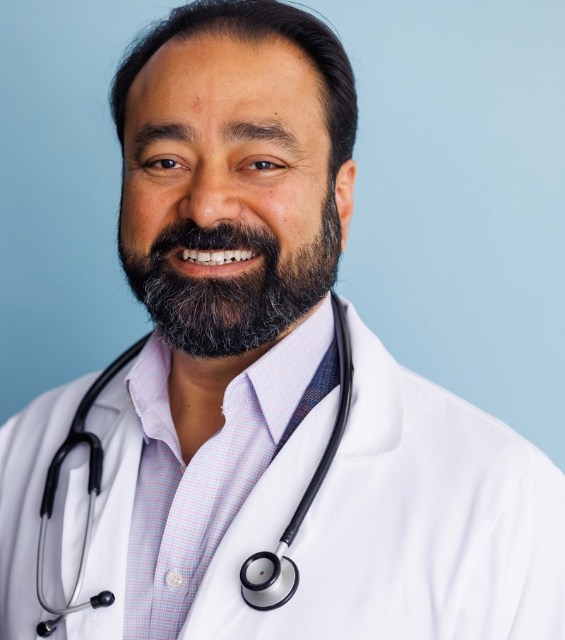 Gautam Kannan, headshot in white doctor's coat and stethoscope
