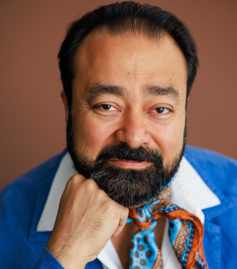Gautam Kannan, headshot in blue jacket and patterned scarf