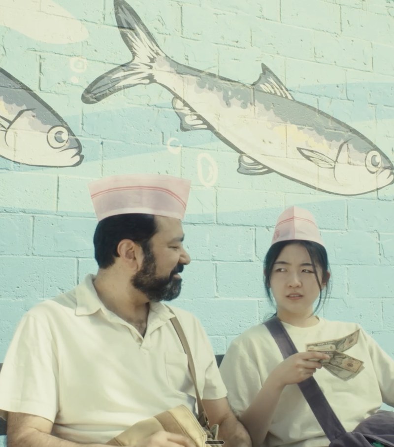 Gautam Kannan as Kabir in short film, "Where Did the Bubble Man Go?", seated on a bench beneath a fish mural